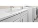 Clean laundry room with white cabinetry, modern sink, and new model washer and dryer at 4639 Garofalo Rd, Wesley Chapel, FL 33543