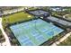 Aerial shot of tennis courts with blue and green surfaces enclosed with black fences at 4639 Garofalo Rd, Wesley Chapel, FL 33543