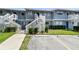 Exterior view of a two-story condo building with white stairs and green landscaping in front at 6033 34Th W St # 45, Bradenton, FL 34210