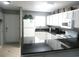 A kitchen featuring black countertops, ceramic tile flooring, white cabinets and appliances at 6033 34Th W St # 45, Bradenton, FL 34210