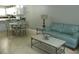 Living room featuring a turquoise sofa, coffee table, dining table, and kitchen at 6033 34Th W St # 45, Bradenton, FL 34210