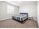 Cozy bedroom with a plush striped bed, window, and bedside table at 10920 Flint Estates Dr, Thonotosassa, FL 33592