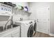 Well-organized laundry room with sink, storage, and modern washer and dryer for added convenience at 10920 Flint Estates Dr, Thonotosassa, FL 33592