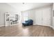 Comfortable living room featuring a blue chair, built-in shelving, and double doors, perfect for relaxation at 10920 Flint Estates Dr, Thonotosassa, FL 33592
