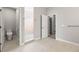 Well-lit main bathroom with a toilet, shower, and open doorway to the walk-in closet providing ample space at 10920 Flint Estates Dr, Thonotosassa, FL 33592