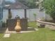 Backyard with tiki bar, outdoor grill, landscaping, chimney, and white vinyl fence at 1279 Dinnerbell E Ln, Dunedin, FL 34698