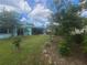 Expansive backyard with mature landscaping, lush green lawn, and tiki bar at 1279 Dinnerbell E Ln, Dunedin, FL 34698