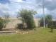 Backyard with mature tree landscaping, fencing, and tiered garden beds at 1279 Dinnerbell E Ln, Dunedin, FL 34698
