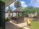 Backyard featuring a tiki bar, outdoor grill, landscaping, and chimney at 1279 Dinnerbell E Ln, Dunedin, FL 34698