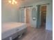 A bedroom featuring a queen bed, en suite bath, modern sliding door, and built in closet space for storage at 1279 Dinnerbell E Ln, Dunedin, FL 34698