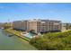 Waterfront condo with a swimming pool, private boat dock, and lush landscaping near the water at 19451 Gulf Blvd # 204, Indian Shores, FL 33785