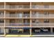 Multi-story building featuring individual units with balconies, covered parking, and club access at 19451 Gulf Blvd # 204, Indian Shores, FL 33785