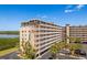 Well-maintained waterfront condo building with lush palm trees, private parking, and waterfront views at 19451 Gulf Blvd # 204, Indian Shores, FL 33785
