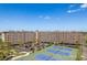 Aerial shot of the condo building, parking, lush landscape, and blue tennis courts in a resort setting at 19451 Gulf Blvd # 204, Indian Shores, FL 33785