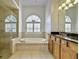 Elegant bathroom showcases a soaking tub, glass shower, granite countertops, and dual sinks at 9413 Swift Creek Cir, Dover, FL 33527