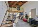 Lofted garage area with a wooden staircase and a variety of stored items at 9413 Swift Creek Cir, Dover, FL 33527