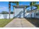 A well-maintained garage on a sunny day with a long driveway and palm trees at 9413 Swift Creek Cir, Dover, FL 33527