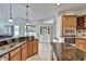 Kitchen with island, granite counters, wood cabinets, and access to the outdoor patio at 9413 Swift Creek Cir, Dover, FL 33527