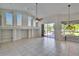 Bright living room with high ceilings, tile floors, and sliding glass doors to the patio at 9413 Swift Creek Cir, Dover, FL 33527