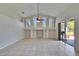 Bright living room featuring a high ceiling, tiled floors, and sliding doors to the outdoor patio at 9413 Swift Creek Cir, Dover, FL 33527