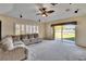 Large living room with ceiling fan, large windows, and sliding glass door to the backyard at 9413 Swift Creek Cir, Dover, FL 33527