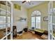 Home office featuring wood floors, natural light from windows, and a built-in shelf at 9413 Swift Creek Cir, Dover, FL 33527