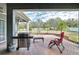 Covered brick patio with a grill and seating overlooking the lush backyard at 9413 Swift Creek Cir, Dover, FL 33527