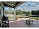Covered brick patio features ceiling fan and relaxing view of the green backyard at 9413 Swift Creek Cir, Dover, FL 33527