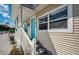 View of front porch with blue door and nice landscaping at 1000 Oak St, Dunedin, FL 34698