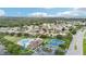 An aerial photograph showcasing the community pool, tennis courts, and residential homes in the area at 1919 Blue River Rd, Holiday, FL 34691