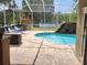 Enjoy this private, screened pool with a waterfall feature and lake views at 1919 Blue River Rd, Holiday, FL 34691