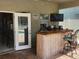 Outdoor poolside bar, complete with a bamboo facade, stool seating, and mounted TV at 1919 Blue River Rd, Holiday, FL 34691