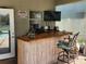 Outdoor poolside bar, complete with a bamboo facade, stool seating, and mounted TV at 1919 Blue River Rd, Holiday, FL 34691