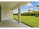 View of the expansive backyard from the covered porch with sleek concrete flooring at 5283 Everlong Dr, Apollo Beach, FL 33572