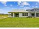 Spacious backyard showcasing lush green lawn, a covered patio, and the back of the home at 5283 Everlong Dr, Apollo Beach, FL 33572