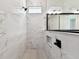 Modern bathroom shower featuring marble-patterned tile and matte black fixtures at 5283 Everlong Dr, Apollo Beach, FL 33572