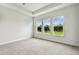 Bedroom featuring plush carpeting, tray ceilings, and multiple windows for natural light at 5283 Everlong Dr, Apollo Beach, FL 33572