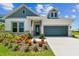 Charming home exterior showcases a well-manicured lawn, beautiful flowerbeds and a gray two-car garage at 5283 Everlong Dr, Apollo Beach, FL 33572