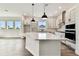 Modern kitchen featuring a large kitchen island, white cabinetry, and stainless steel appliances at 5283 Everlong Dr, Apollo Beach, FL 33572