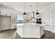 Modern white kitchen with island, pendant lighting, stainless steel appliances, and stylish backsplash, great for cooking at 5283 Everlong Dr, Apollo Beach, FL 33572