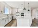 Modern white kitchen with island, pendant lighting, stainless steel appliances, and stylish backsplash, a chef's dream at 5283 Everlong Dr, Apollo Beach, FL 33572