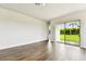 Bright living room featuring wood-look floors and sliding glass doors that lead to the backyard at 5283 Everlong Dr, Apollo Beach, FL 33572