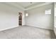 Main bedroom featuring plush carpeting, tray ceiling, and ensuite bathroom at 5283 Everlong Dr, Apollo Beach, FL 33572