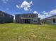 A view of the home's backyard featuring a large grassy lawn and a covered patio at 4319 Pullet Ct, Bradenton, FL 34211