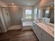 Bright bathroom with a glass-enclosed shower, tub, double vanity, and wood look plank floors at 4319 Pullet Ct, Bradenton, FL 34211