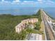 Beautiful aerial view of the condos near the water featuring a community pool, palms, and highway access at 12077 Gandy N Blvd # 344, St Petersburg, FL 33702