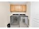 Modern laundry room featuring front loading machines and light wood cabinets for storage, plus a nice neutral paint at 12077 Gandy N Blvd # 344, St Petersburg, FL 33702