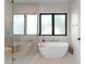 Modern bathroom featuring a soaking tub, glass enclosed shower, and a large window at 2517 N Riverside Dr, Tampa, FL 33602