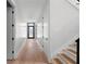 Long hallway featuring modern doors, hardwood floors, and access to the staircase at 2517 N Riverside Dr, Tampa, FL 33602