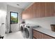 Functional laundry room featuring modern washer and dryer, counter space, and natural lighting at 2517 N Riverside Dr, Tampa, FL 33602